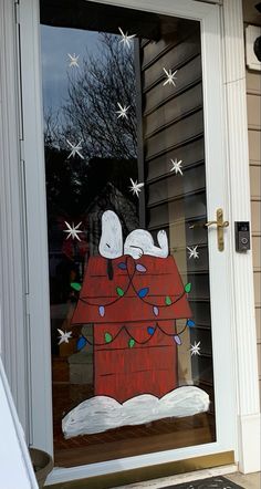 a door decorated with a christmas scene and dog sleeping on top of a sleigh