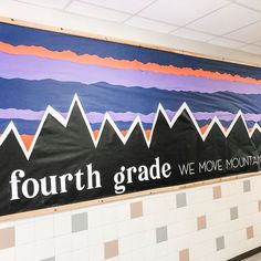 a sign on the side of a wall that says fourth grade we move mountains with mountain tops