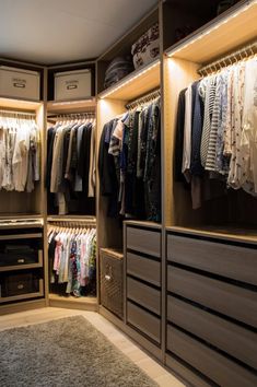 an organized closet with clothes hanging on the shelves, drawers and other items in it