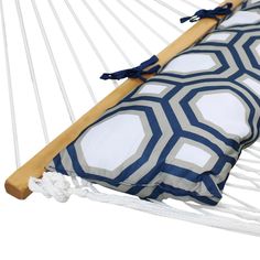 a white and blue hammock with a pillow on the bottom, in front of a white background