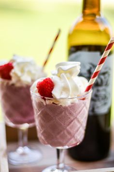 two glasses filled with ice cream and raspberries