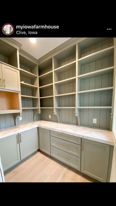 an empty kitchen with white cabinets and gray cupboards