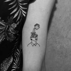 a black and white photo of a woman's arm with a cup of coffee on her head