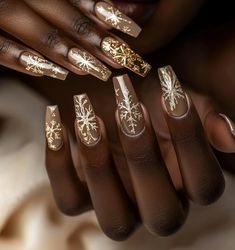 A pair of elegantly manicured hands with long, almond-shaped nails featuring festive holiday nail art. The nails are decorated in shades of deep red, gold, and white, with intricate designs including snowflakes, sparkles, and candy cane stripes. The background is softly blurred, enhancing the focus on the nails and giving a warm, cozy holiday ambiance. Christmas Nails Acrylic Silver, Christmas Nails Acrylic Gold, Professional Holiday Nails, Christmas Nails Simple Classy Almond, January Sweater Nails, Gold Holiday Nails Christmas, Fancy Christmas Nail Designs, Tan Christmas Nails, Christmas Nails Black Women