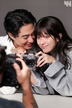 a man and woman taking pictures with a camera