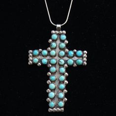 This is a stunning Vintage Native Zuni Turquoise Cross Pendant Necklace 26 Snake Eye Stones Sterling Silver 21g. This gorgeous LARGE handmade cross pendant necklace features 26 large snake eye turquoise stones that are sawtooth bezel set embellished with 34 raindrops. The 21 1/2" snake chain is hallmarked F.N.A./925/Italy. All the turquoise stones are in excellent condition with no cracks. There are matrix lines and one stone includes some pyrite. The cross was handmade by a skilled silversmith.  Condition: Excellent Vintage  Style: Cross Pendant Necklace Metal: 925 Sterling Silver (tested positive) Chain:  21 1/2" inches Pendant: 2 3/4" x 1 7/8"     Surface: Some patina/tarnish with slight polish Weight: 21 grams Hallmark: None- Unsigned  Tribal Affiliation:  Zuni #26629963 Handmade Southwestern Cross Necklace, Southwestern Handmade Cross Necklace, Handmade Turquoise Cross Jewelry, Handmade Southwestern Style Cross Pendant Jewelry, Handmade Southwestern Cross Pendant Jewelry, Handmade Turquoise Cross Necklace, Handmade Turquoise Cross Necklace Spiritual, Handmade Spiritual Turquoise Cross Necklace, Southwestern Silver Cross Pendant Necklace