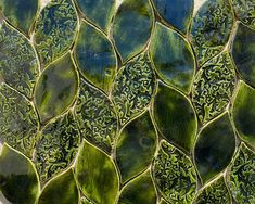 a close up view of a green mosaic tile