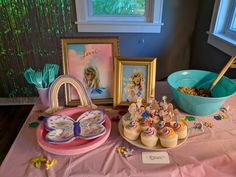 a table topped with pictures and cupcakes next to a bowl of cereal on top of a table