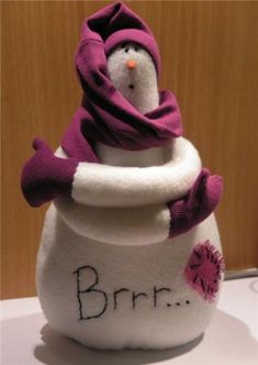 a stuffed snowman sitting in a pot with the word brrr written on it