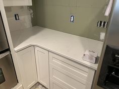 a kitchen with white cabinets and appliances in the process of remodeling it