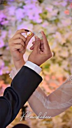 the bride and groom are holding their wedding rings