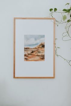 a painting hanging on the wall next to a potted plant