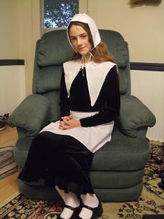 a woman sitting in a chair wearing a nun costume