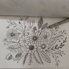 a drawing of flowers and leaves on a piece of paper with a marker next to it