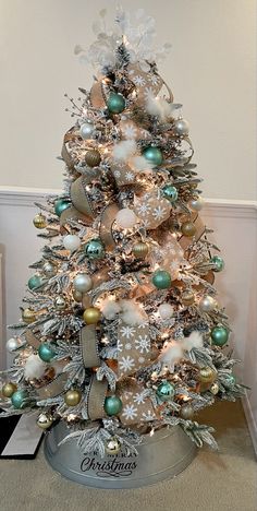 a white christmas tree with green and gold ornaments