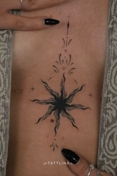 a woman's stomach with an intricate tattoo design on her chest and hands holding onto the