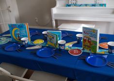 a blue table topped with plates and books