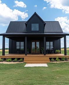 a black house sitting on top of a lush green field