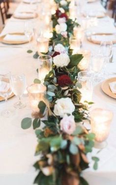 a long table with candles and flowers on it