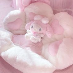 a stuffed animal in a pink and white bed