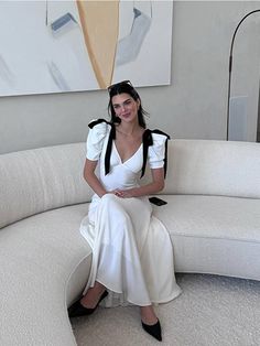 a woman sitting on top of a white couch