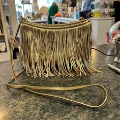 Stunning Gold Fringed Crossbody. Italian Leather.One Exterior Slip Pocket Larger Phones Will Fit. Zippered Close. Interior Of The Bag Has A Small Zippered Pocket And A Long Slip. Store Displayed Only. New, Never Used. Elegant Gold Bag With Fringe, Gold Fringe Party Bag, Leather Clutch Purse, Hobo Crossbody Bag, Long Slip, Gold Fringe, Fringe Bags, Hobo Bags, Black Leather Crossbody Bag