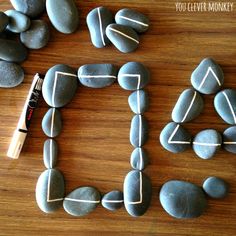 some rocks are arranged to spell out the word love on a wooden surface with a marker