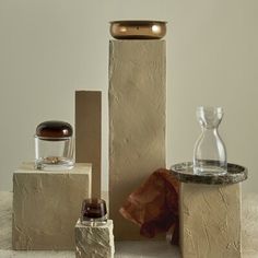 three different types of vases sitting on top of stone blocks and one is empty