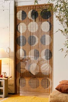 a living room with a large bamboo screen in the center and pillows on the floor