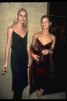 two women standing next to each other in dresses