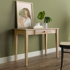 a wooden table sitting next to a green wall with a potted plant on it