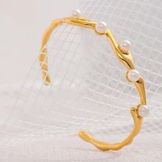 Pearls Twist Cuff Bracelet The Pearls Twist Cuff Bracelet is a stunning accessory that combines timeless elegance with modern design. Crafted from stainless steel and plated with 24k gold, this bracelet is both luxurious and durable. Materials This bracelet isn't just beautiful; it's also practical. The 24k gold plating ensures it stays radiant, while the waterproof feature means you can wear it without worry, even during daily activities. Metal: Stainless Steel 24k Gold Plated Imitation Pearls Pearl Cuff Bracelet, Pearl Cuff, Waterproof Jewelry, Gifts For Sister, Velvet Bag, Daily Activities, Pearl Bracelet, Earring Necklace, Ring Necklace