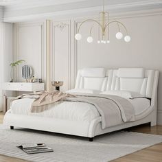 a white bed sitting on top of a wooden floor