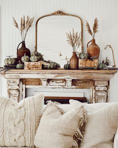 a living room filled with furniture and a fire place covered in pillows on top of a white couch