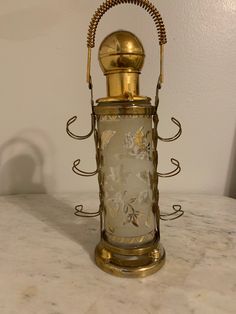 an antique brass and glass lantern on a marble table