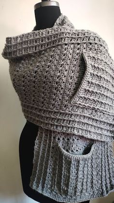 a gray knitted shawl on top of a mannequin