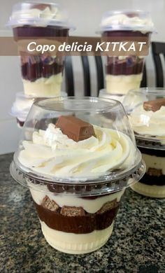 cupcakes with whipped cream and chocolate on top in plastic cups sitting on a counter