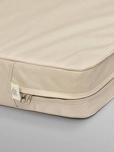 an open zippered mattress on a gray surface