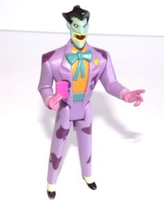 the toy figure is wearing a purple suit and pink shoes with an orange shirt on