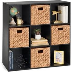 a black bookcase with four baskets and two books on the top one is filled with books