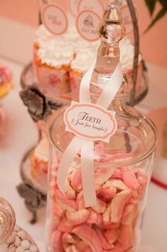 there is a glass jar filled with candy and candies next to other sweets on the table