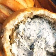 a close up of a bread bowl filled with blue cheese and some baguettes