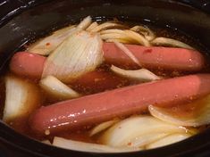 hot dogs and onions cooking in a slow cooker