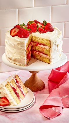 there is a strawberry cake with one slice cut out and the other half on a plate