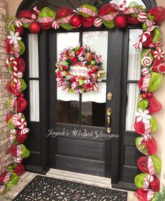 a decorated front door for christmas with candy canes and wreath on the glass window