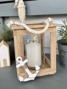 a candle holder with an anchor, seahorse and rope on the front door porch