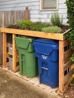 two trash cans sitting next to each other in front of a wooden bench with plants growing out of them