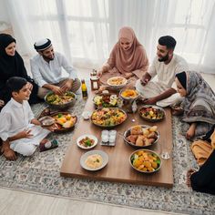 a group of people sitting around a table full of food