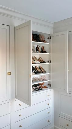 a white closet with several pairs of shoes on the bottom shelf and two rows of drawers