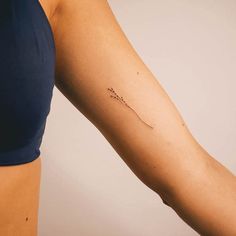 a woman's arm with a small tattoo on the left side of her arm